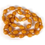 A string of Art Deco faceted butterscotch Bakelite amber beads, the largest bead 3cm (1.24ins) long.