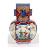 A Japanese Imari vase, decorated with a goldfish and prunus, with gilt highlights, 25cm (9.75ins)