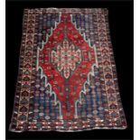 A Hamadan rug with central gul on a blue ground, 130 by 196cms (51 by 77ins).