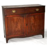 A 19th century mahogany cupboard with lift-up faux frieze drawer, above two doors enclosing a