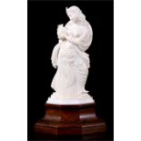 A late 19th / early 20th century Indian ivory figure of a dancing girl holding a vase, on hardwood
