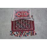 A Persian Turkomen wall hanging decorated with geometric pattern on a red ground, 106 by 65cms (41.