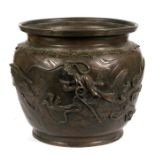 A Chinese bronze jardiniare, decorated in relief with dragons and birds, 25cms (9.75ins) diameter.