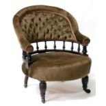 A Victorian button back tub chair with turned spindles, standing on ring turned legs.