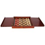 An Edwardian mahogany folding travelling chess set with ivory pieces.
