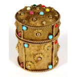 A gilt metal box of cylindrical form, set with semi precious stone cabochons, 10cm (4ins) high.