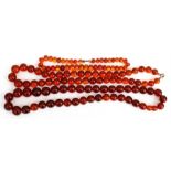 Two amber bead necklaces together with an amber coloured bead necklace, 37cms (14.5ins), 64cms (25.