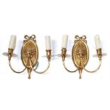 A pair of brass rams head twin arm wall lights.