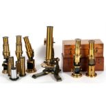 A quantity of brass student microscopes, lenses and spares.