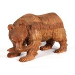 A large Black Forest style carved wooden bear, 43cm (17ins) long.