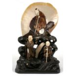 A 19th century shibayama group depicting an Immortal and two figures, 31cms (12.25ins) high.