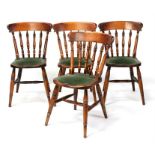 A set of four spindle back pub chairs with upholstered seats.