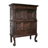 A 19th century Flemish carved oak court cupboard, the figural carved doors above further