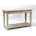 A painted pine hall table with single short frieze drawer, on tapering legs with under tier,