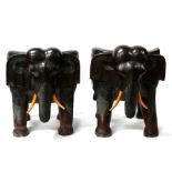 A pair of African hardwood stump chairs carved in the form of elephants, 66cms (26ins) wide.