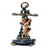 A cast iron double stick stand in the form of a winged cherub, 66cms (26ins) high.