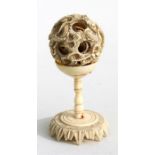 A 19th century Chinese ivory puzzle ball on stand, deeply carved with scrolling dragons, 10cms (