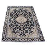 An Isfahan woollen hand-made rug with foliate design, navy on beige ground, 300 by 200cms (118 by