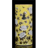 A Chinese wig stand of cylindrical form, decorated with flowers and insects on a yellow ground,