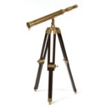A brass telescope on hardwood tripod stand.