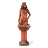 An Egyptian Revival pink concrete garden statue in the form of a semi naked woman, standing on a