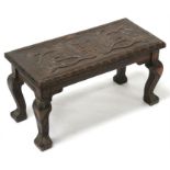 A Victorian carved oak stool, the seat inscribed 'Sit thee Doon', 56cms (22ins) wide.