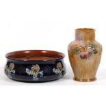 A Royal Doulton stoneware bowl decorated with flowers on a deep blue ground, 21cms (8.25ins) wide;