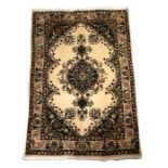 A Kerman woollen hand made rug with foliate design on a cream ground, 138 by 95cms (54 by 37.5ins).