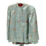 A Chinese silk embroidered short robe or jacket, decorated with scrolling flowers on a pale green