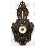 A Black Forest style aneroid barometer thermometer, the frame carved with grapes & vine, 64cms (25.