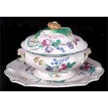 A faience pottery tureen & platter decorated with flowers, the tureen 30.5cms (12ins), the platter
