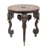 An Anglo-Indian hardwood circular occasional table, the top carved with figures within a foliate