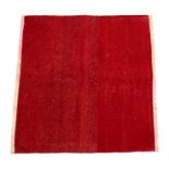 A flat weave monochrome kelim with red ground and beige fringe, 124 by 114cms (49 by 45ins).