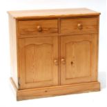 A pine dresser base with two short drawers above two cupboards, on plinth base, 91.5cms (36ins)