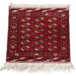 A Persian rug with repeated medallion design on a red ground, 89 by 99cms (35 by 39ins).