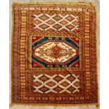 A Caucasian rug with central gul within geometric borders on a burnt orange ground, 161 by 266cms (