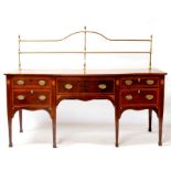 A Georgian mahogany serpentine fronted sideboard, the brass gallery above a frieze drawer flanked by