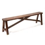 A pine bench, standing on square legs joined by a cross stretcher, 157cm (61.75ins) wide