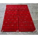 A Bedouin flat weave or kelim red ground rug, 200 by 280cms (78.75 by 110.25ins).
