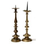 Two mid 17th century cast bronze pricket candlesticks, the spikes centering a shallow drip pan