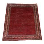 A Persian Sarouk carpet with a repeat design within geometric borders, on red ground, 360 by