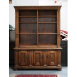 A continental walnut bookcase on cupboard, the open bookcase with six adjustable shelves, above