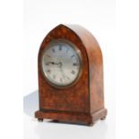 An Edwardian mantle clock, the silvered dial with Roman numerals, the arched burr walnut case