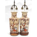 A pair of Chinese vase form table lamps decorated with prunus on a cream ground, 61cms (24ins)