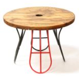 A rustic coffee table with circular pine top standing on saddle rack legs, 79cms (31ins) diameter.