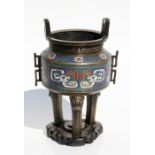 A Chinese bronze and cloisonne three legged censer, decorated with stylised dragons, standing on a