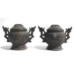 A pair of bronze censers and covers decorated with dragons, 14cms (5.5ins) high.