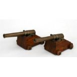 A matching pair of desk top cannons, having bronze barrels and mounted on wooden carriages with