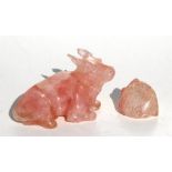 A Chinese rose quartz carving depicting a recumbent ox, 10cms (4ins) high; together with a carved