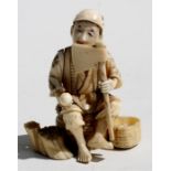 A late 19th century Japanese Meiji period sectional ivory figure depicting a wood cutter, 9cms (3.